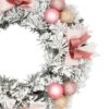 Zasnežený adventný veniec s ružovými vianočnými guľami a ružovými mašľami. Detail